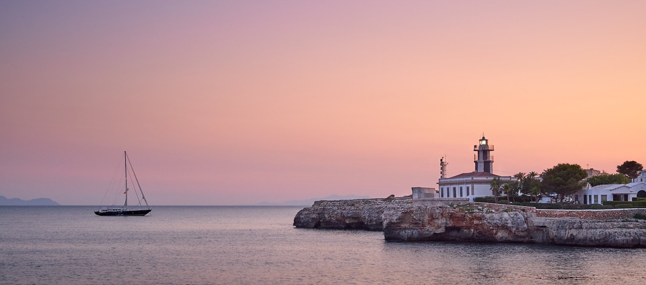 Sunset over a sailing yacht off the coast of Menorca